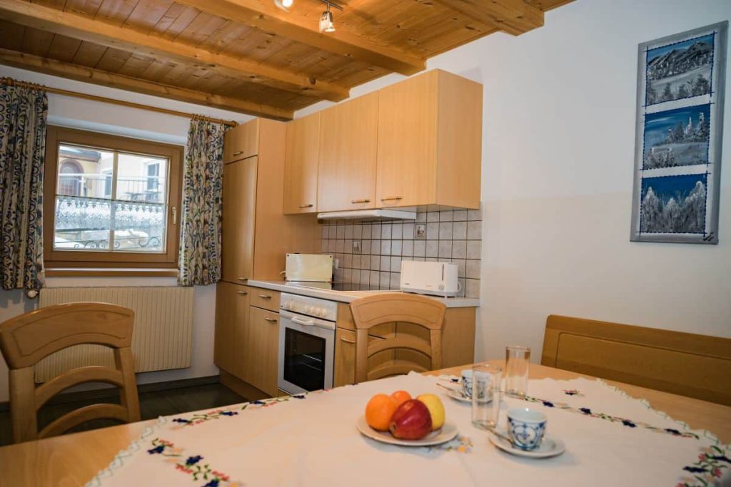 Küche im Bauernhof mit Holzdetails und Tisch mit frischen Äpfeln, ausgestattet und einladend.