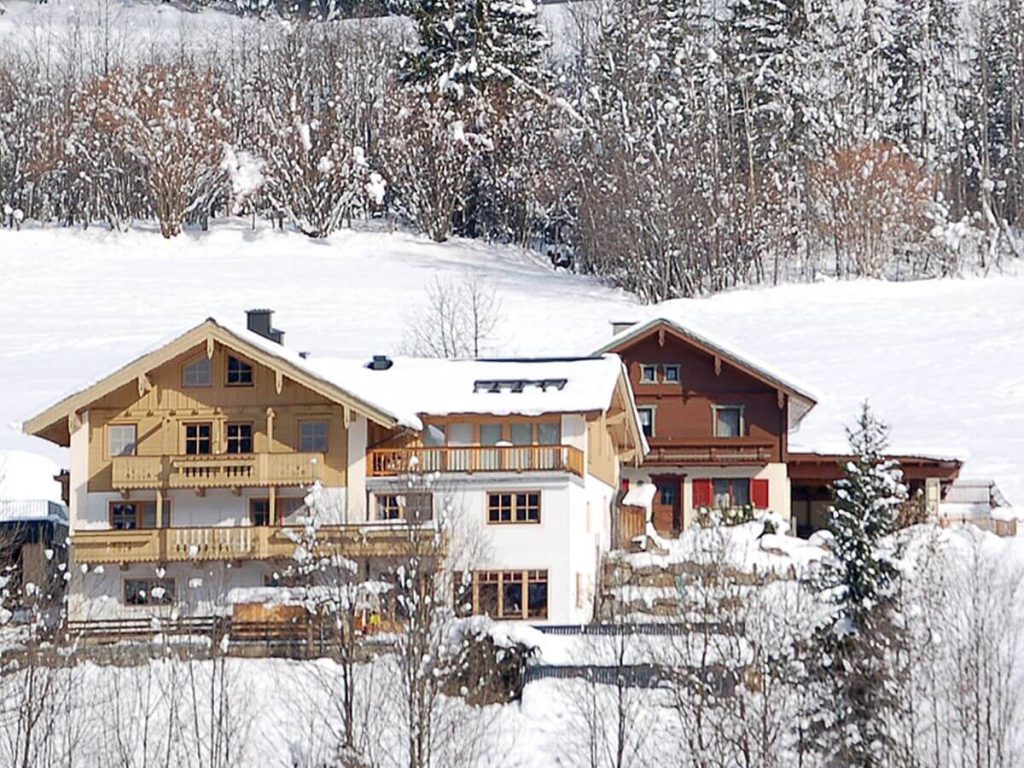 Bauernhof Kreidl in verschneiter Landschaft, umgeben von Bäumen und Bergen im Salzburger Land.